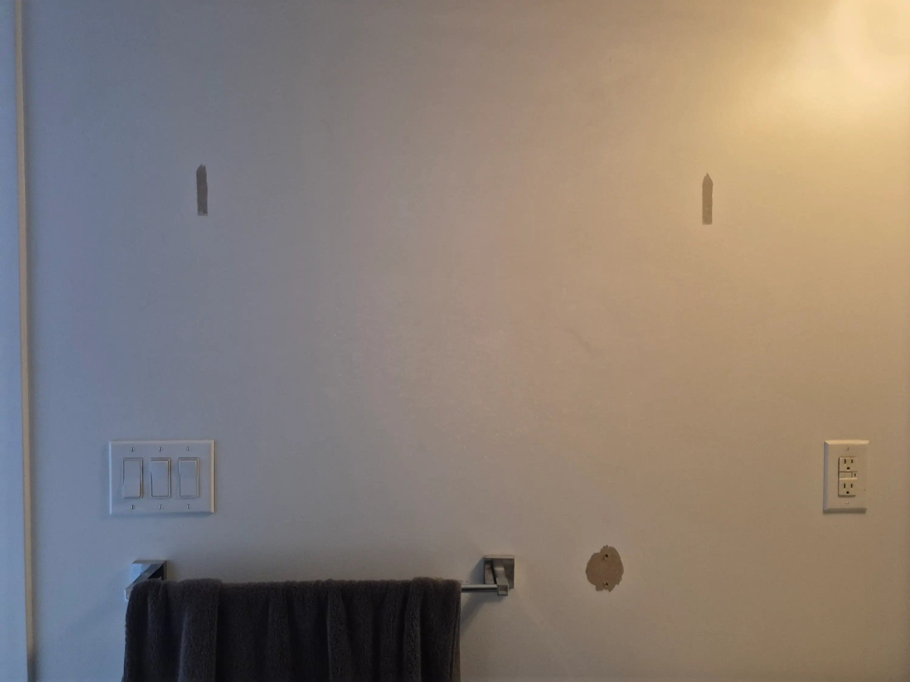 Bubbled and lifted paint on a wall showing a blistering defect before repair