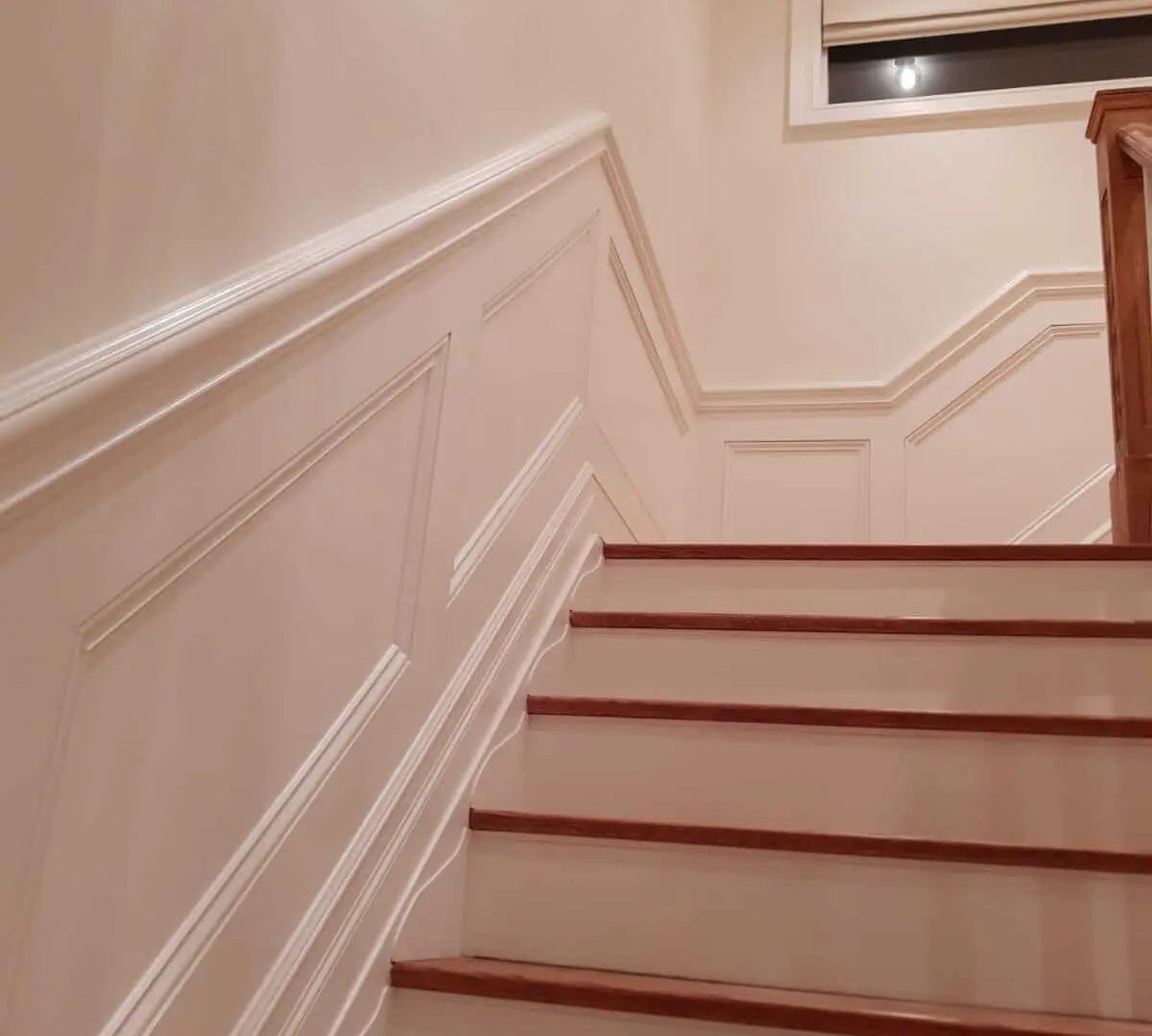 Bare wood trim being primed before paint to seal grain and block tannin bleed