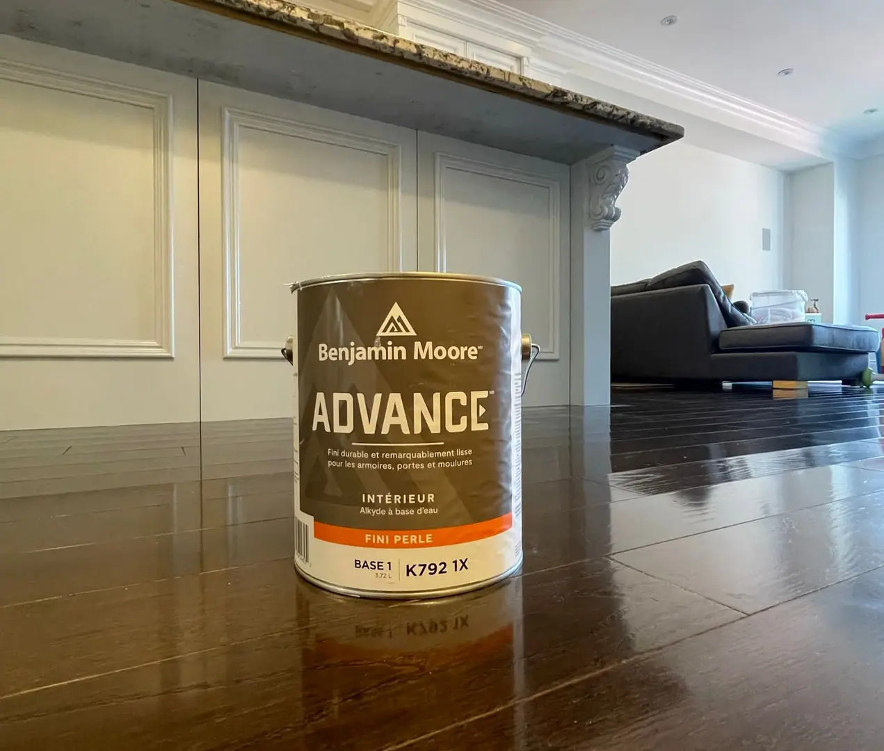 A can of Benjamin Moore Advance waterborne alkyd on the floor in front of finished white kitchen cabinetry in a Toronto home